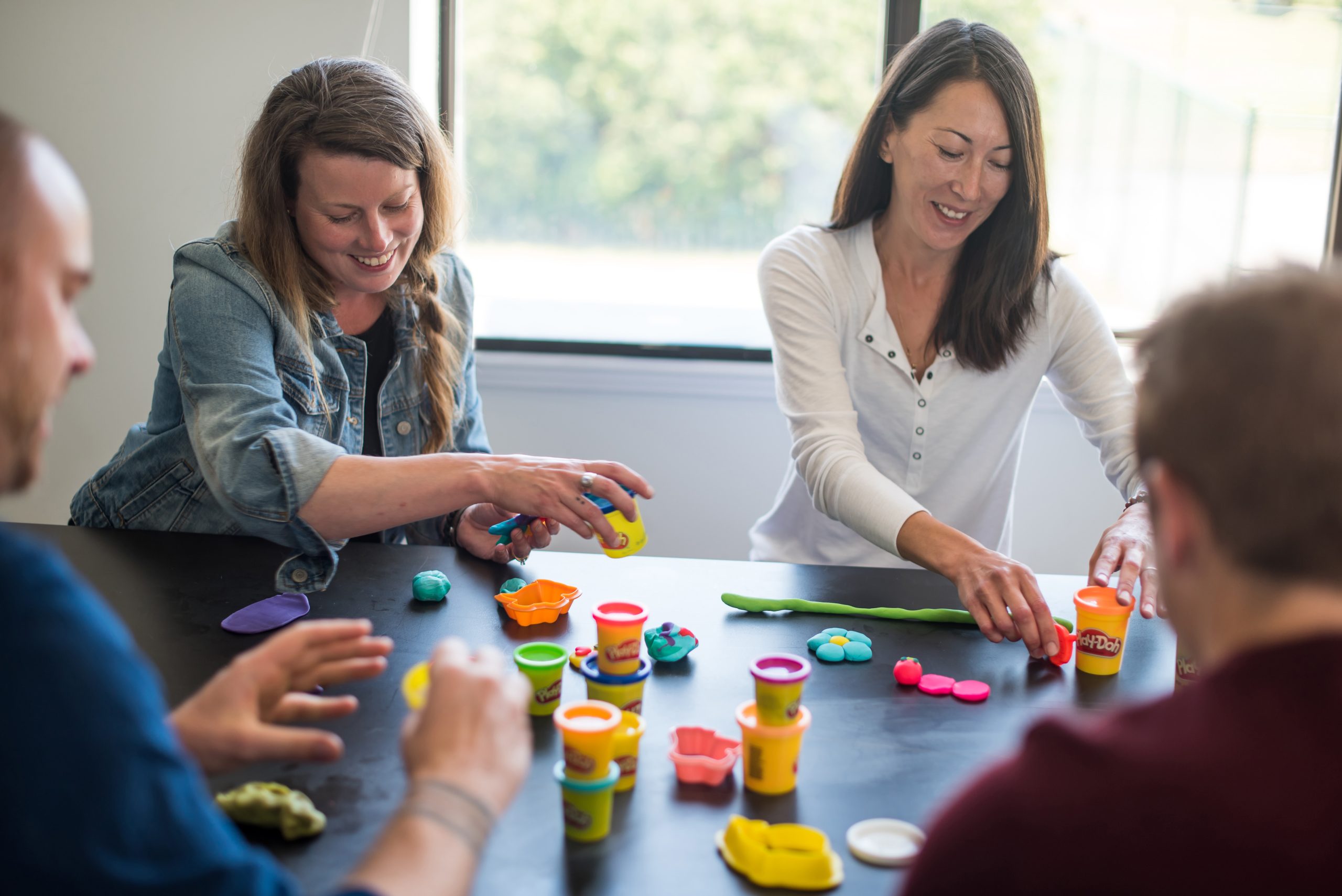 Two women playing PlayDoh Power Solutions Team building